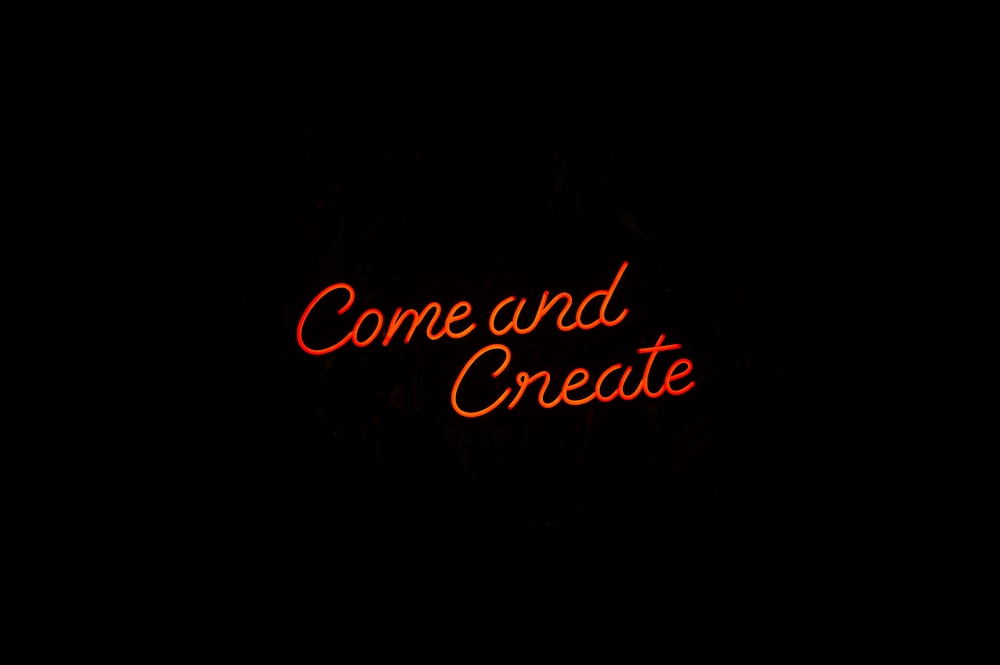 Un'insegna al neon che recita Come e Create