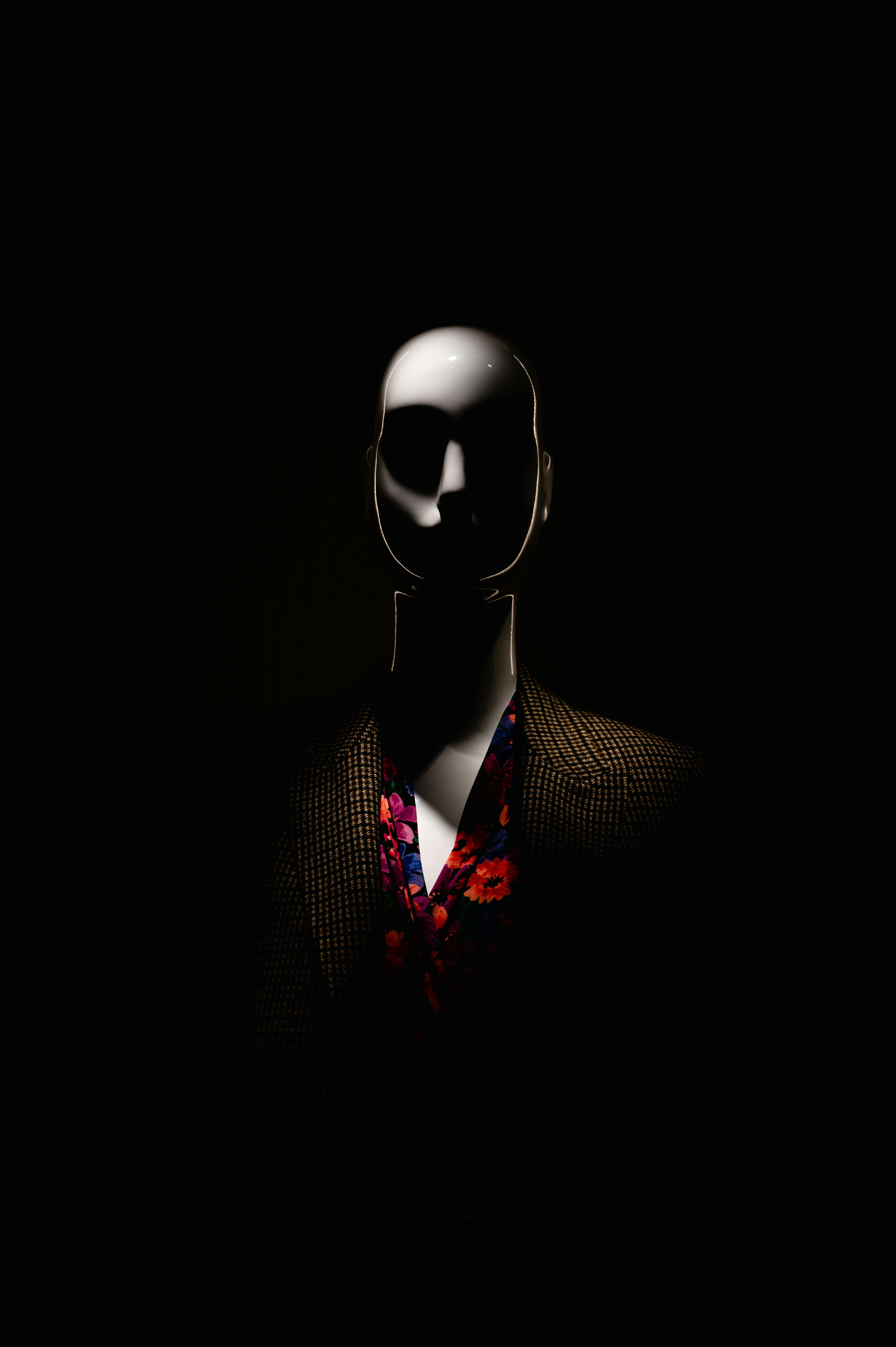 a man in a dark room with his head turned to the side