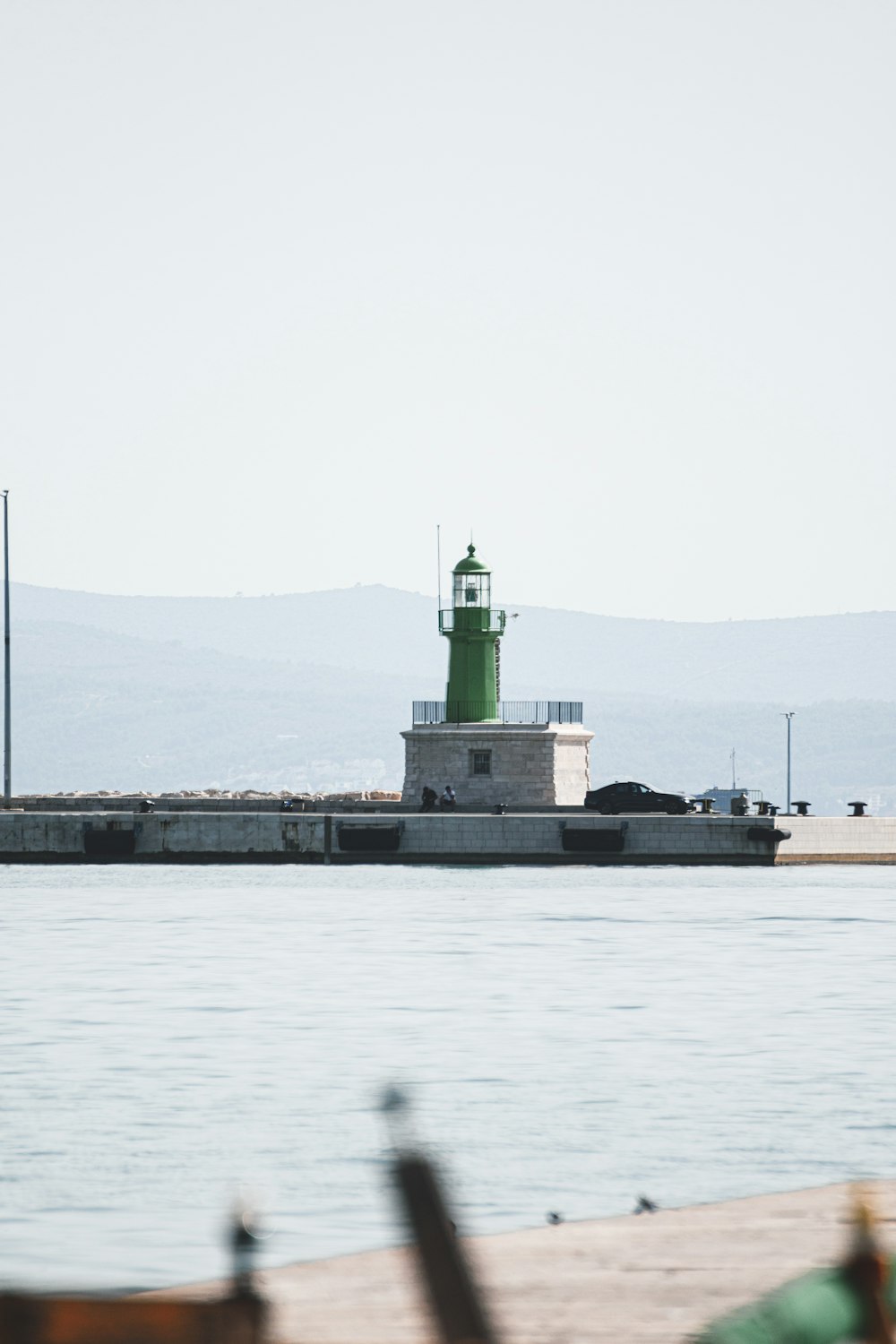 a light house sitting on top of a pier next to the ocean