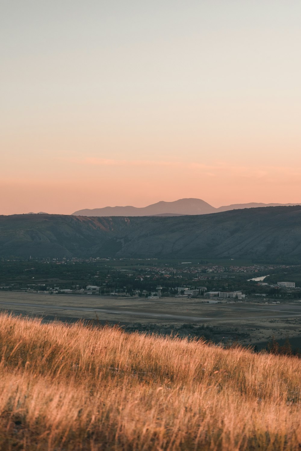 a grassy field with mountains in the background