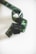 A length of filmstrip is coiled in a loose spiral on a plain, light background. The filmstrip has a glossy appearance with visible perforations along the edges and varying shades of dark, translucent green.