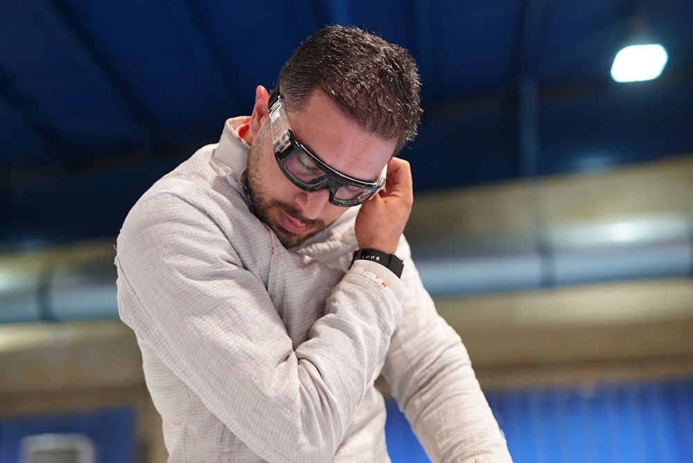 a man in a white sweater and goggles