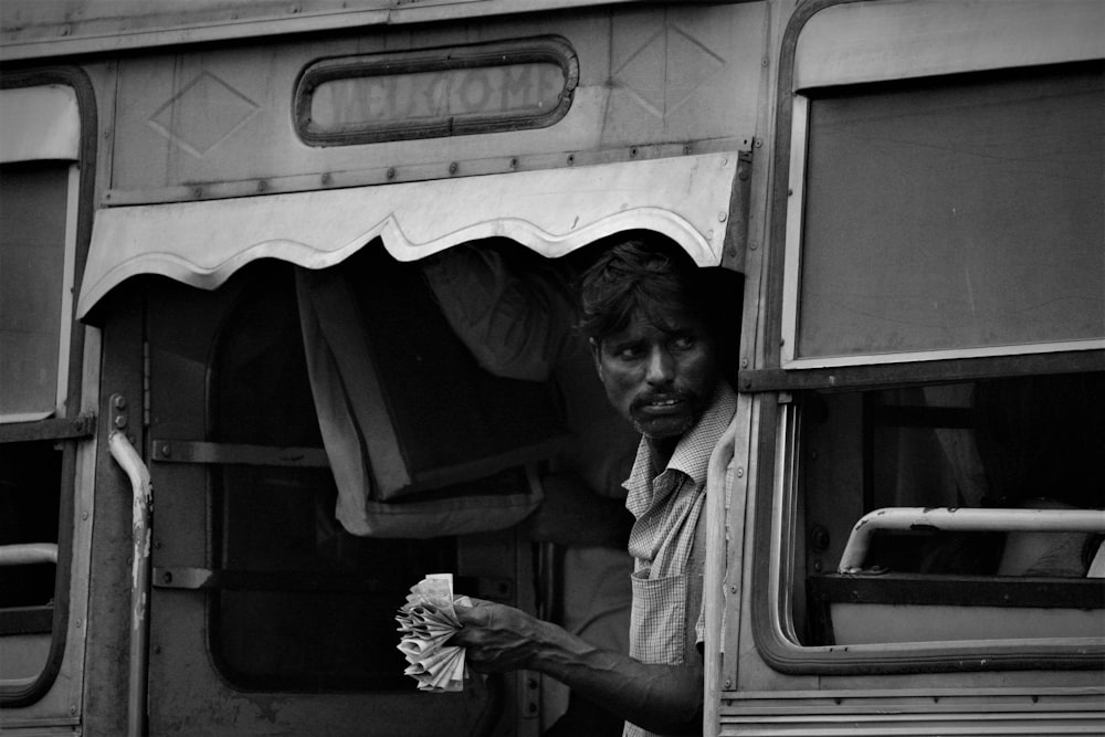 a black and white photo of a man holding a flower