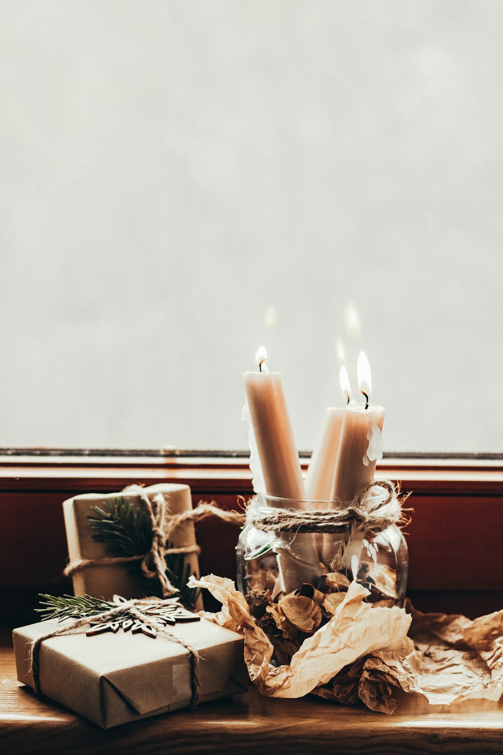 a couple of candles sitting on top of a window sill