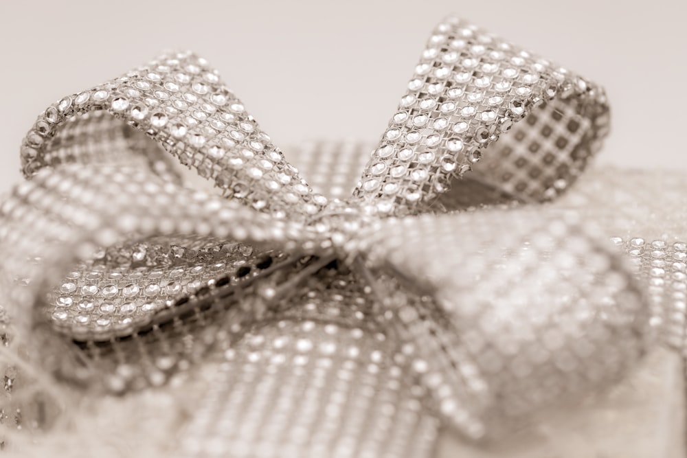 a close up of a silver bow on a white background