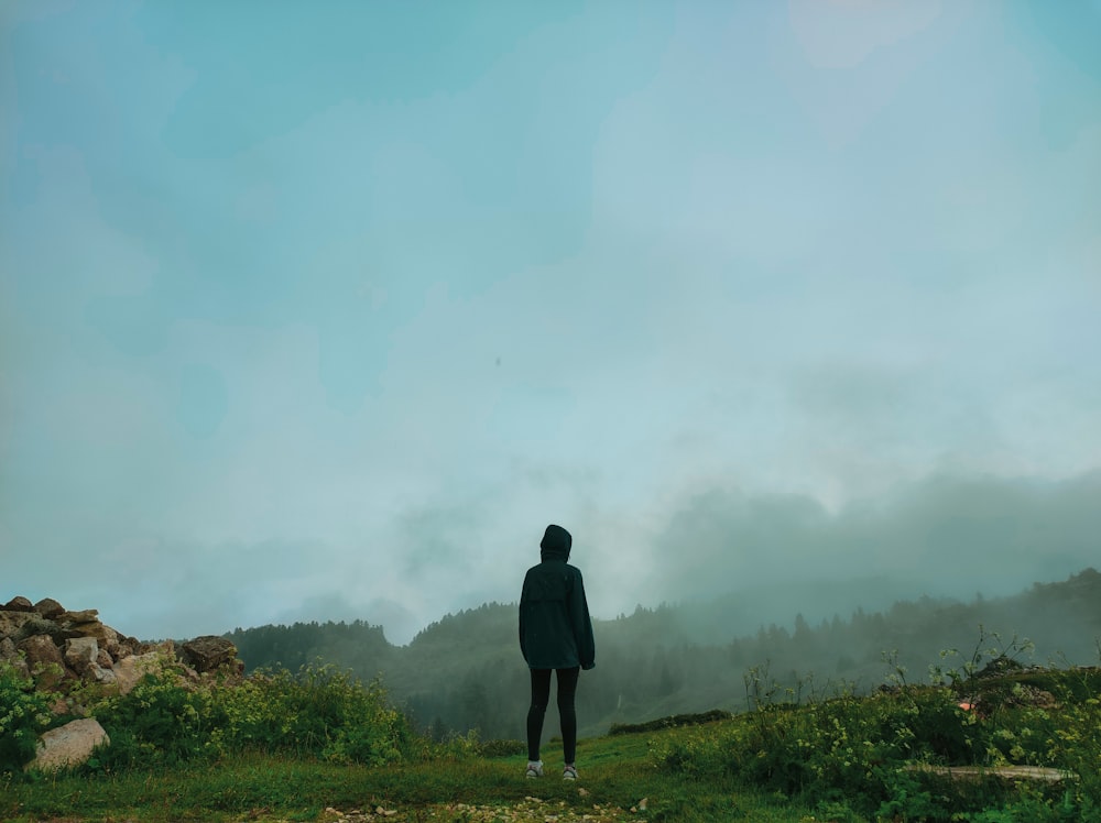 a person standing on top of a lush green field