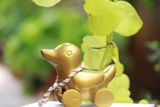 Close-up of a hand holding a small lucky duck figurine.