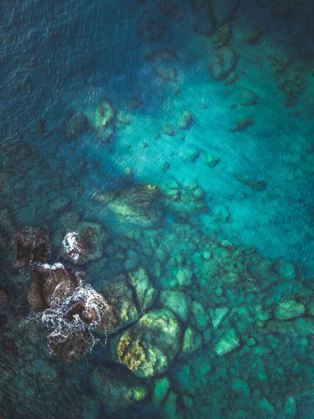 an aerial view of a body of water surrounded by rocks