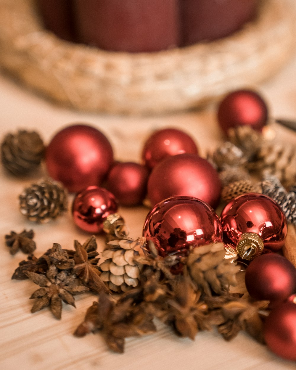 a table topped with red ornaments and pine cones