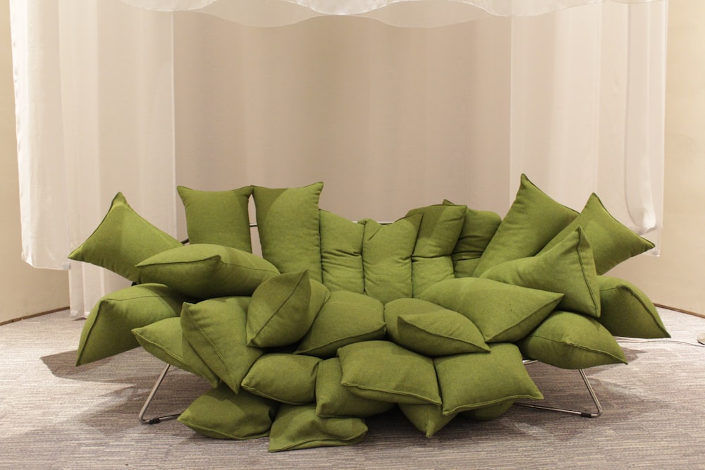 a pile of green pillows sitting on top of a floor