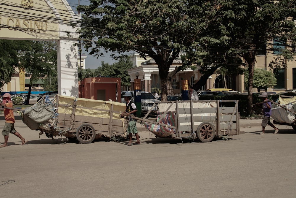 a group of people pushing a cart down a street