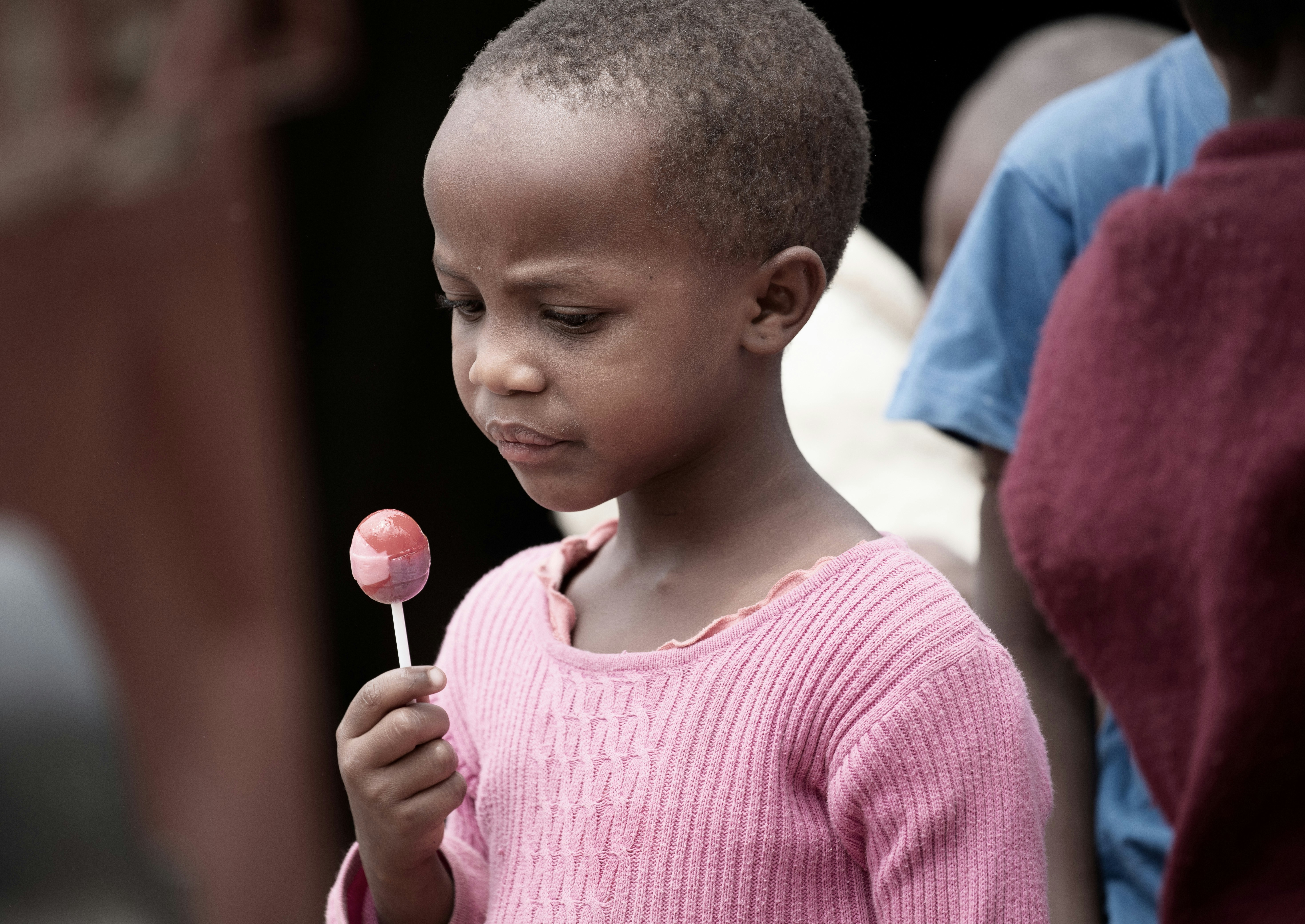 a little boy holding a candy lollipop in his hand