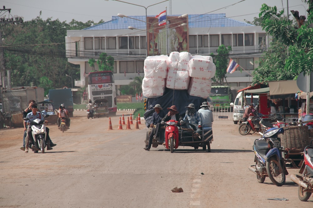 a group of people riding motorcycles down a street