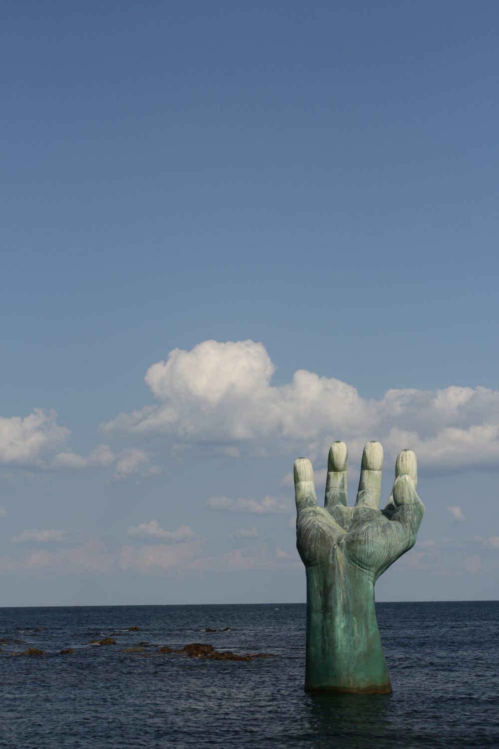 Una estatua de una mano que sobresale del agua