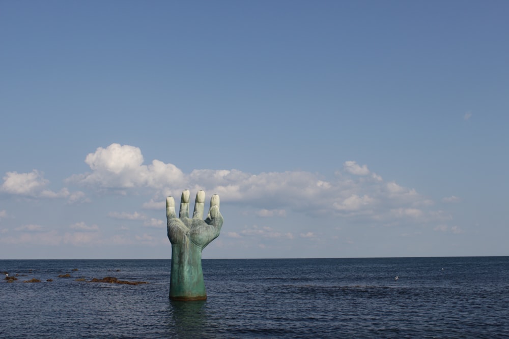 Una estatua de una mano que sobresale del agua