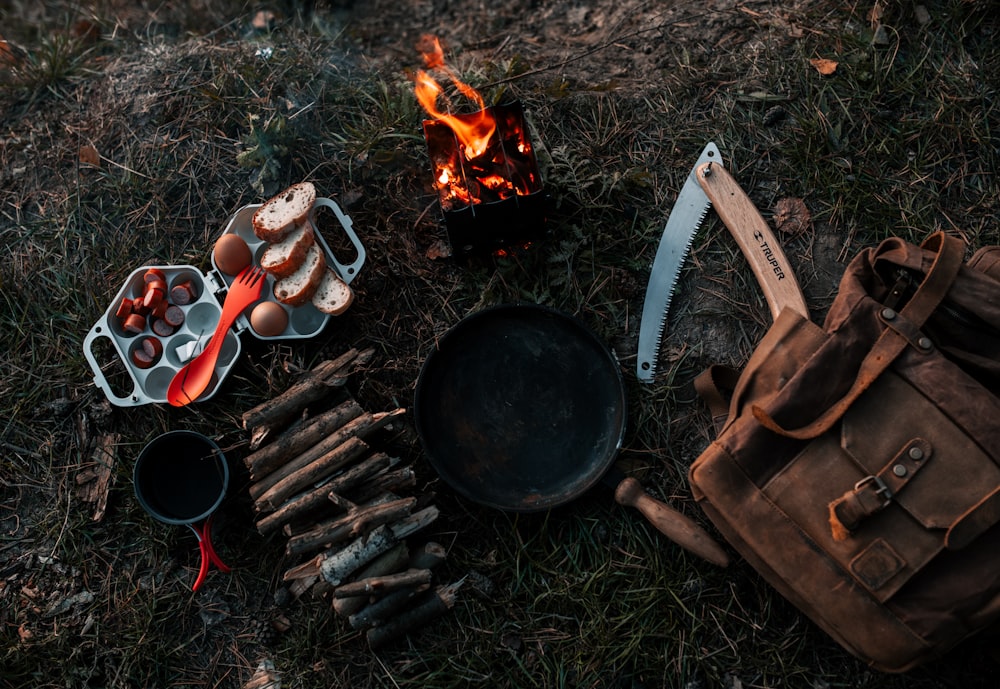 a campfire with a bunch of cooking utensils