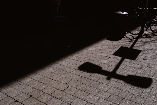 a shadow of a street sign on a sidewalk