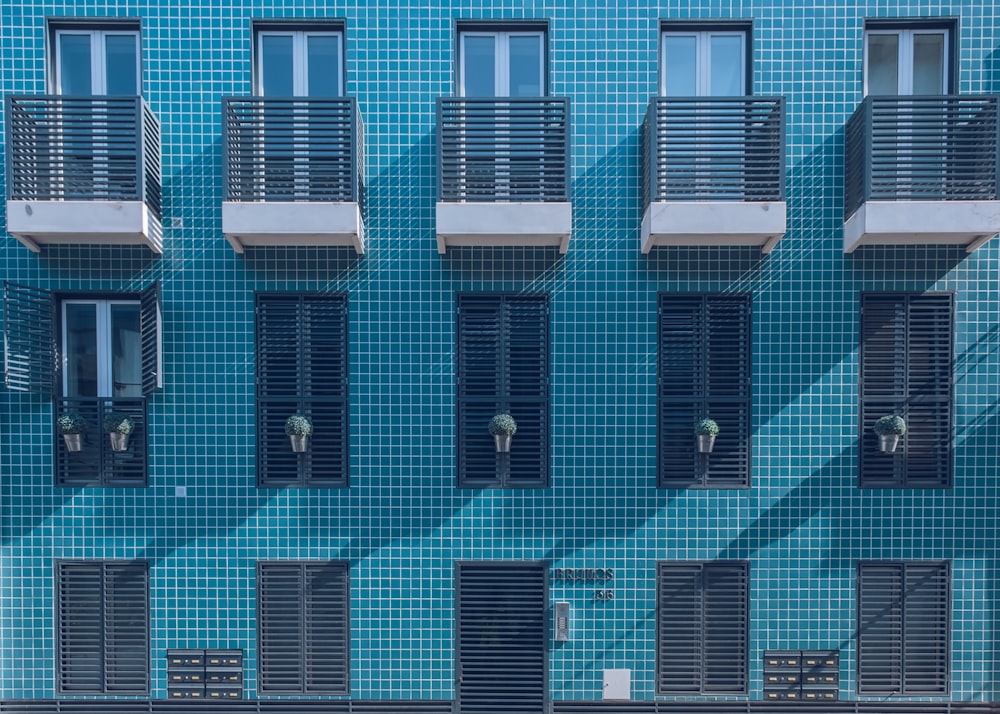 a blue building with many windows and shutters