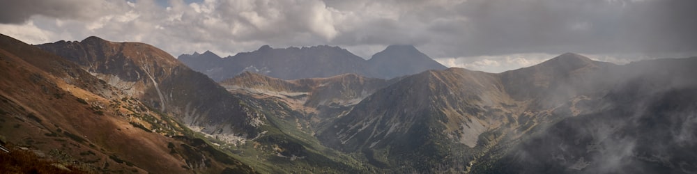 a view of a mountain range with clouds in the sky