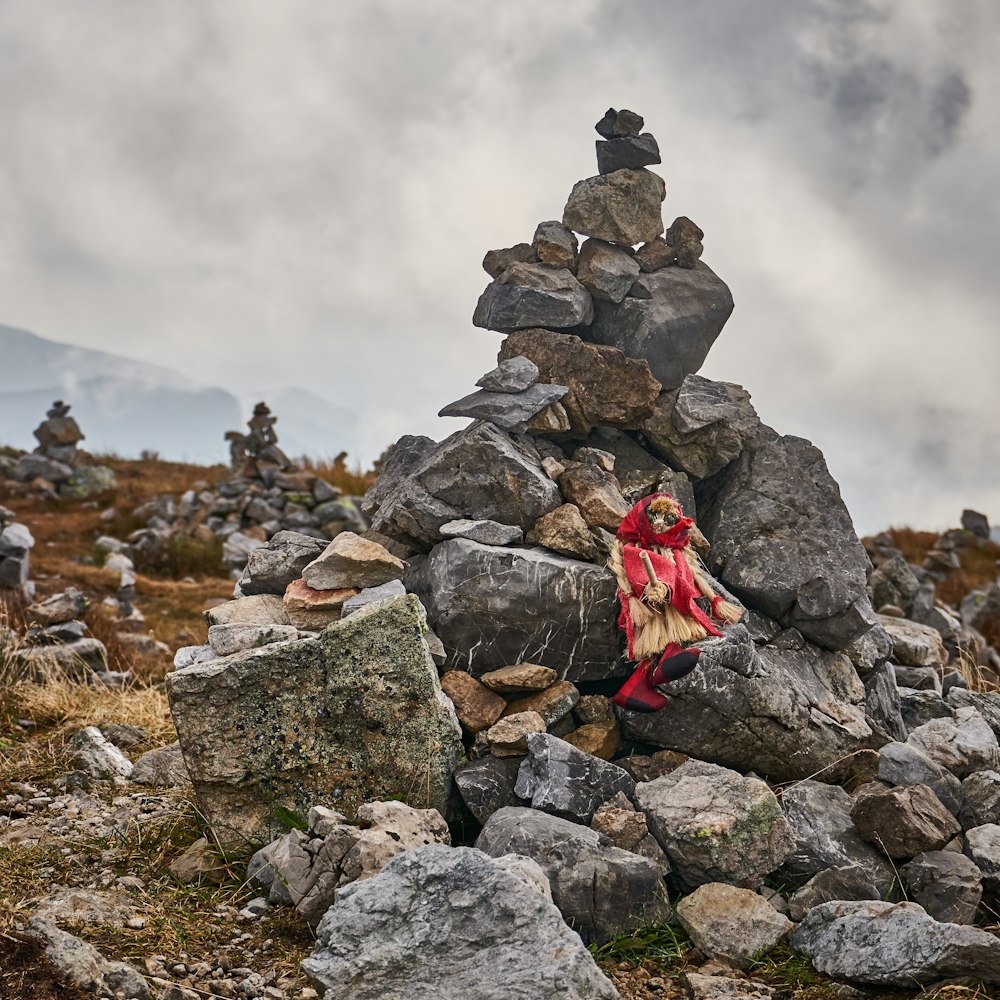 a woman sitting on top of a pile of rocks