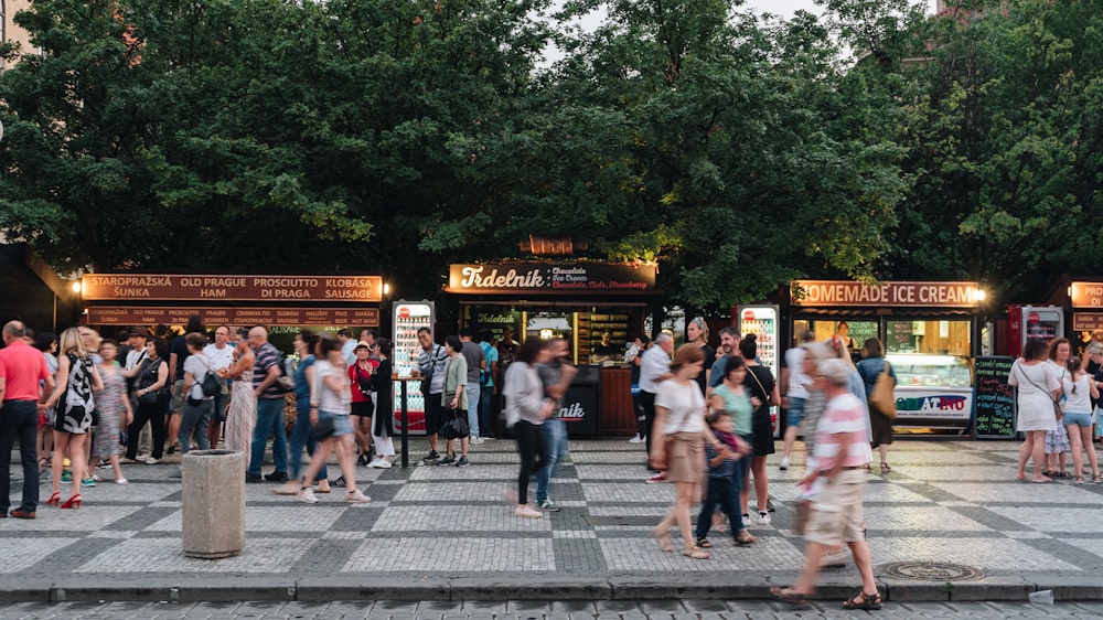 a crowd of people walking around a park