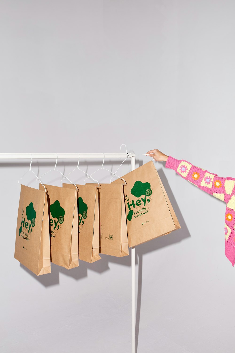 a woman holding a paper bag on a clothes line