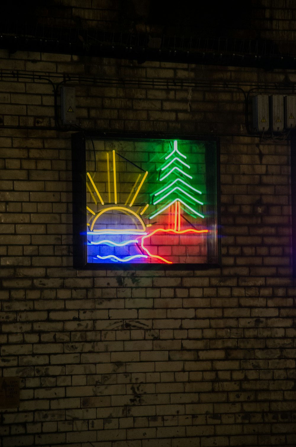 a brick wall with a neon sign on it