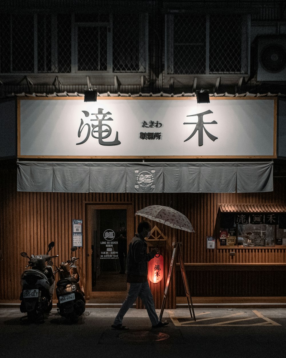 a man walking down a street holding an umbrella