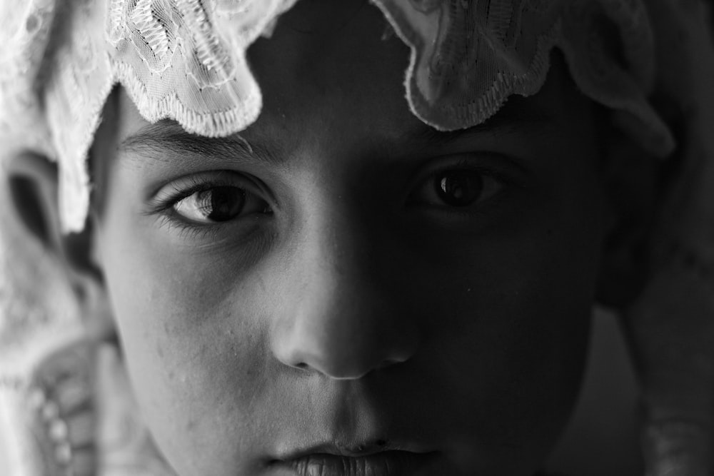 a black and white photo of a young girl wearing a headdress