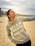 a woman standing on a beach holding a frisbee