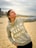 a woman standing on a beach holding a frisbee