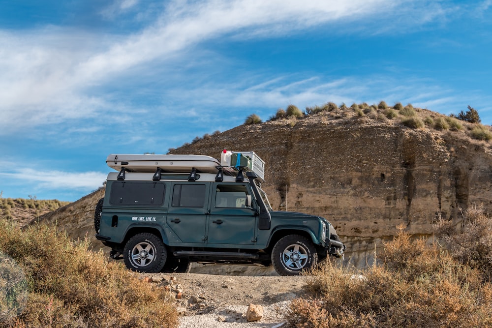 Une jeep est garée sur le bord d’un chemin de terre