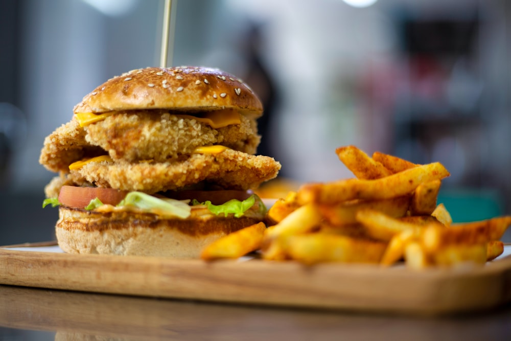 a chicken sandwich and french fries on a cutting board