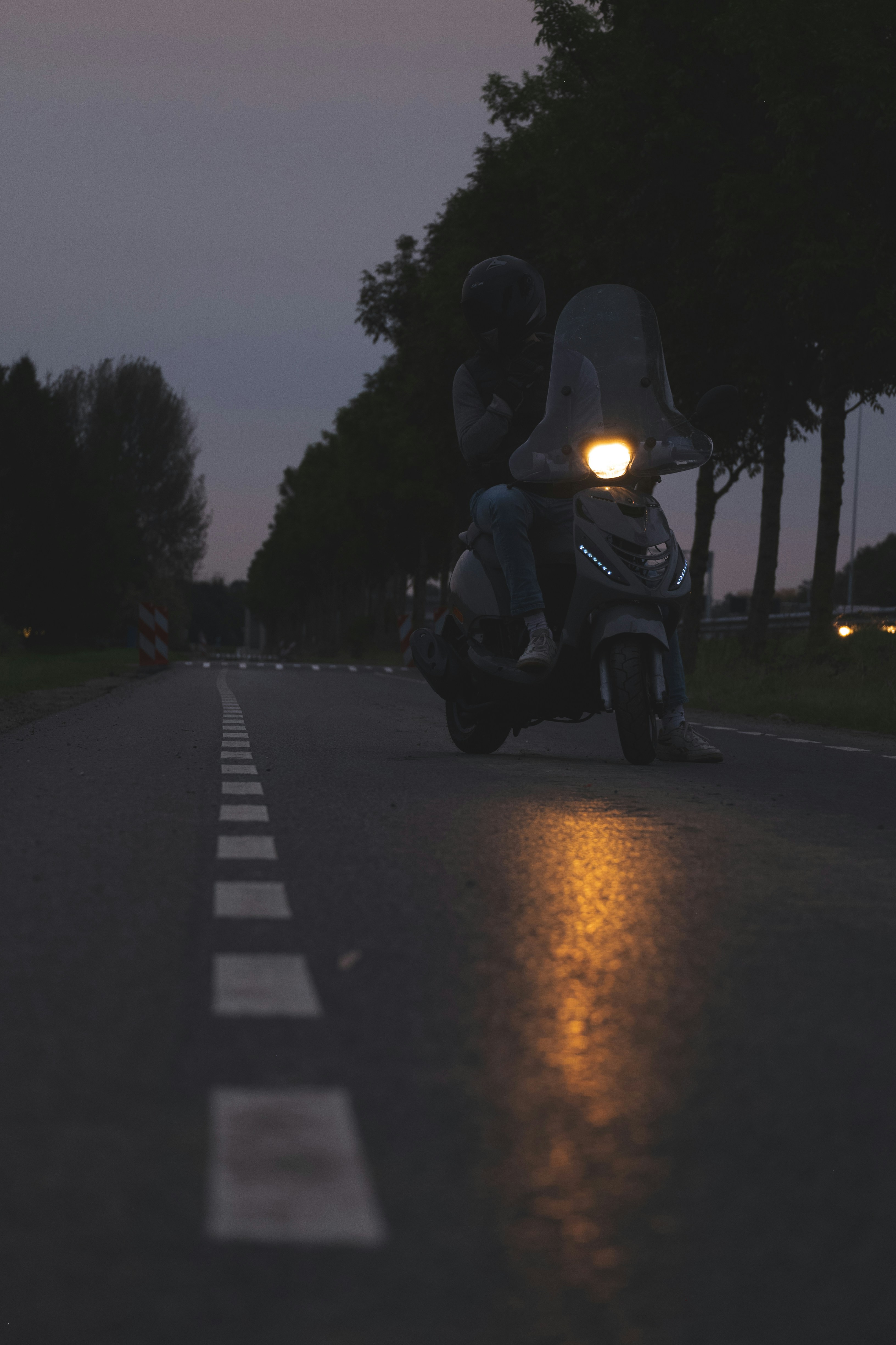 Eine Person, die nachts mit dem Motorrad eine Straße entlang fährt