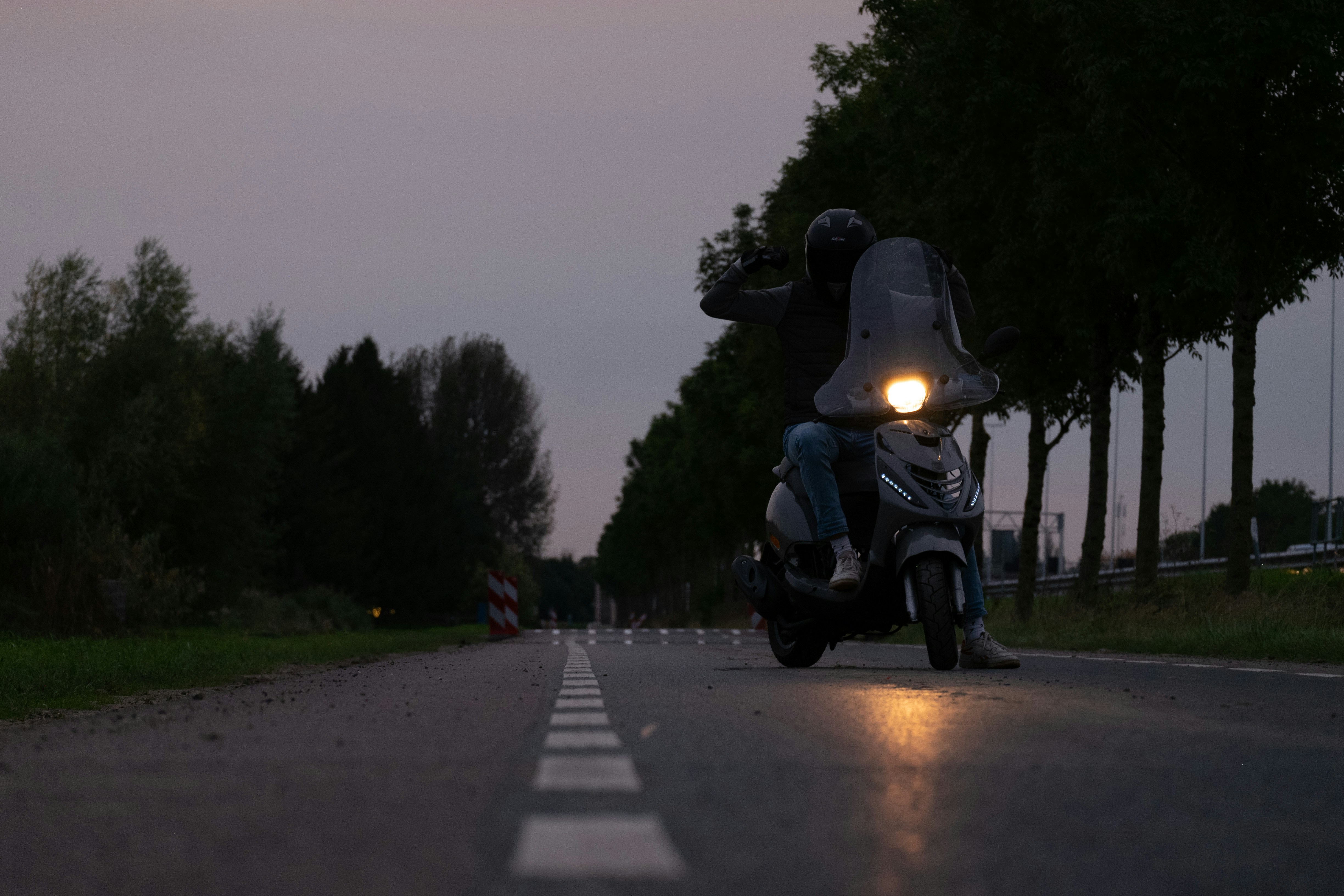 eine Person, die mit einem Motorrad eine Straße entlang fährt