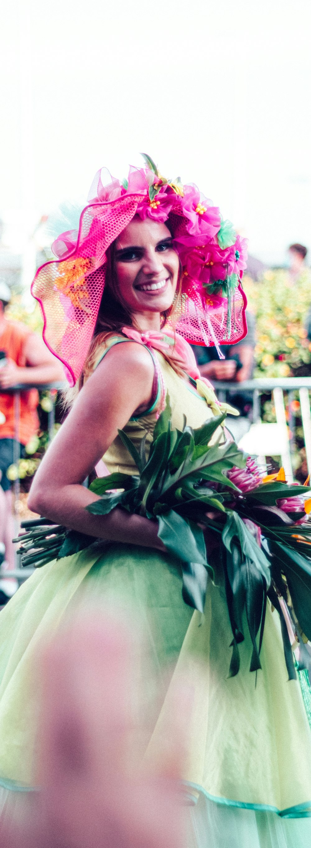 a woman in a green dress and a pink hat