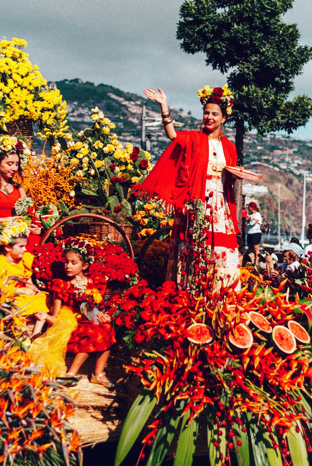 a woman in a red and white dress standing in a field of flowers