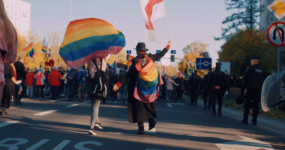 a group of people walking down a street holding flags