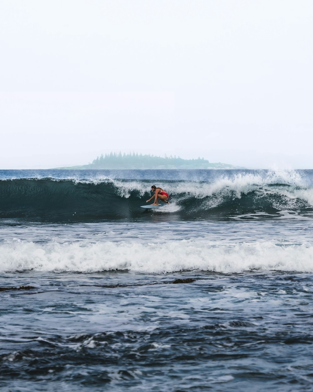 a man riding a wave on top of a surfboard