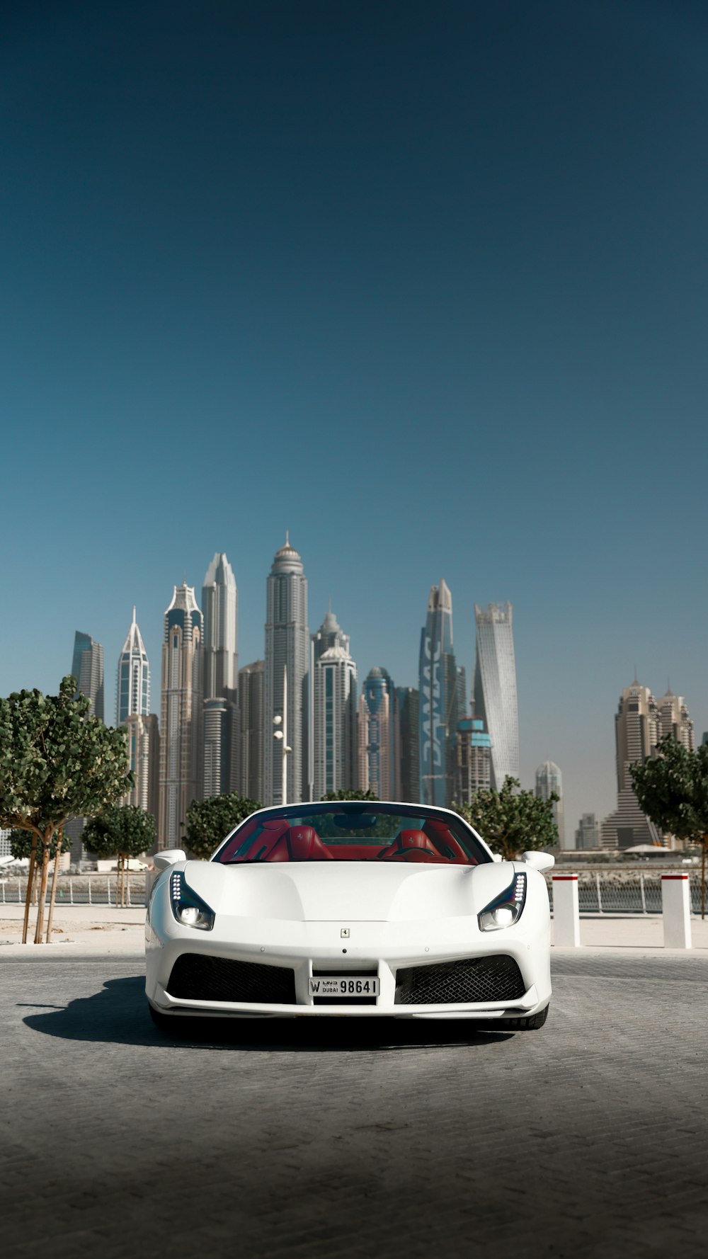 a white sports car parked in front of a city