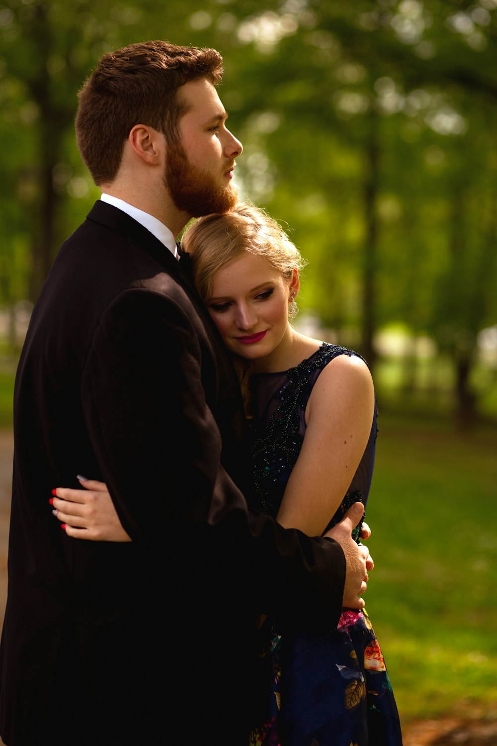 a man and a woman embracing in a park