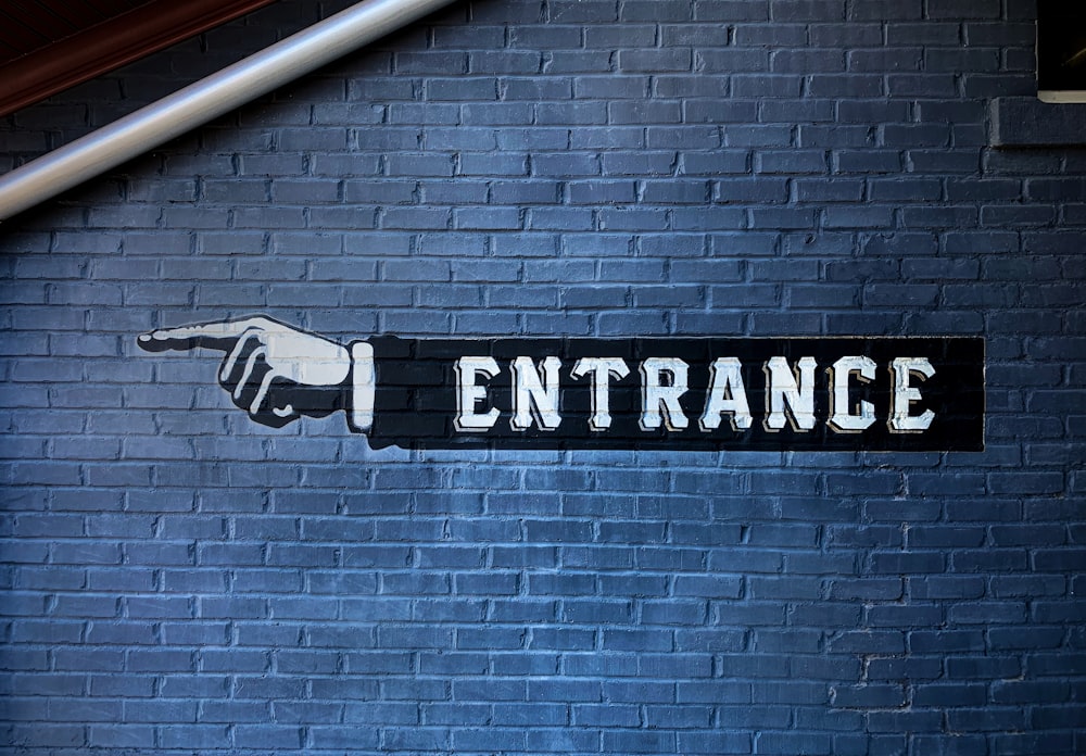 a brick wall with a sign that says entrance