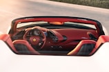 a red sports car driving down a road