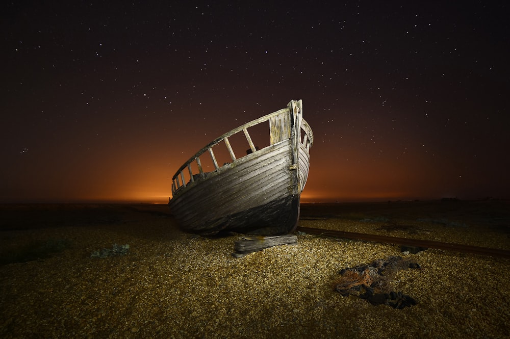 a boat sitting on top of a dry grass field