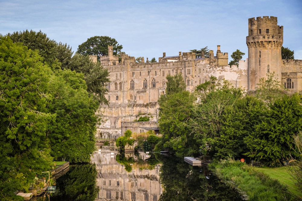 a castle is reflected in the water of a river