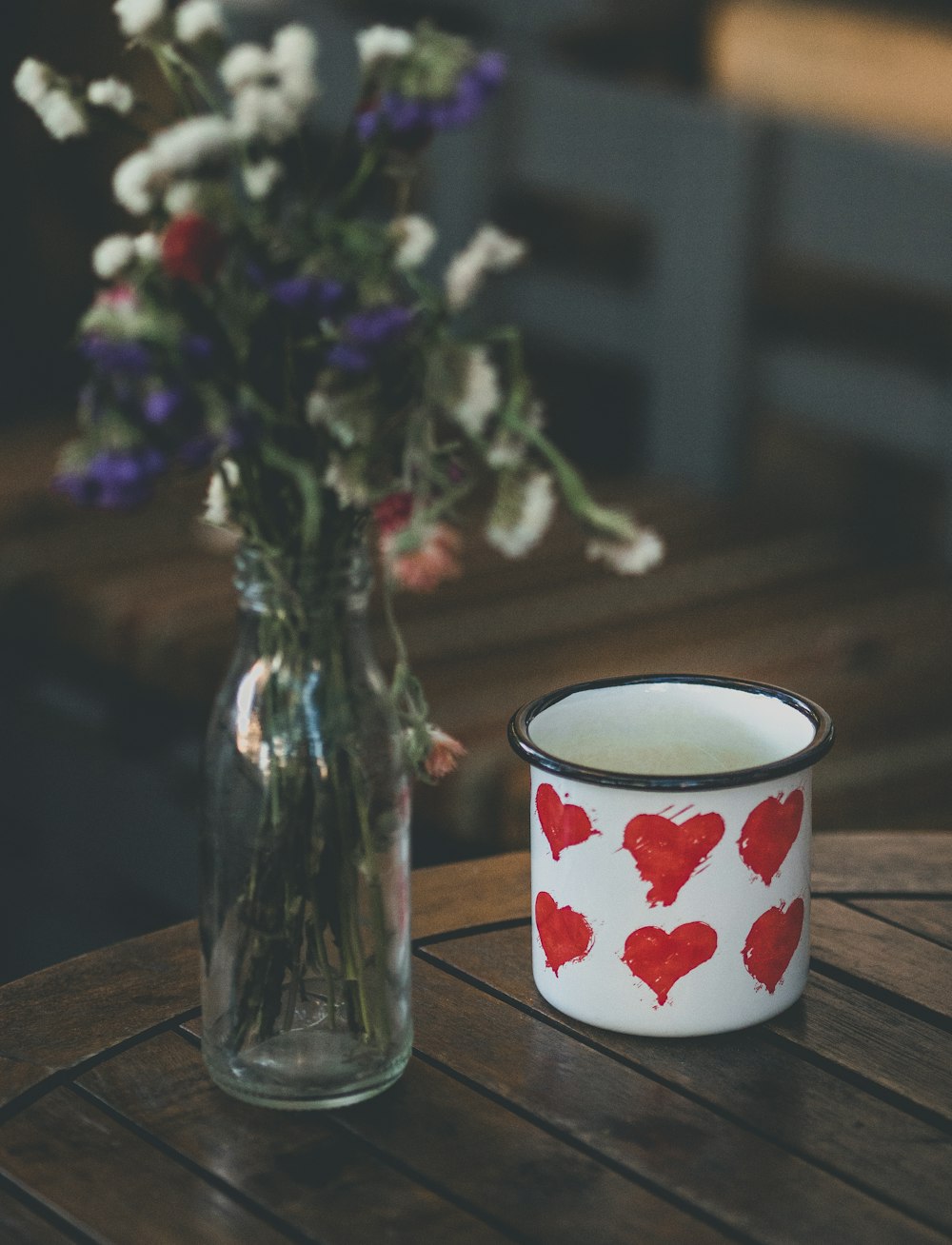 a vase of flowers and a candle on a table