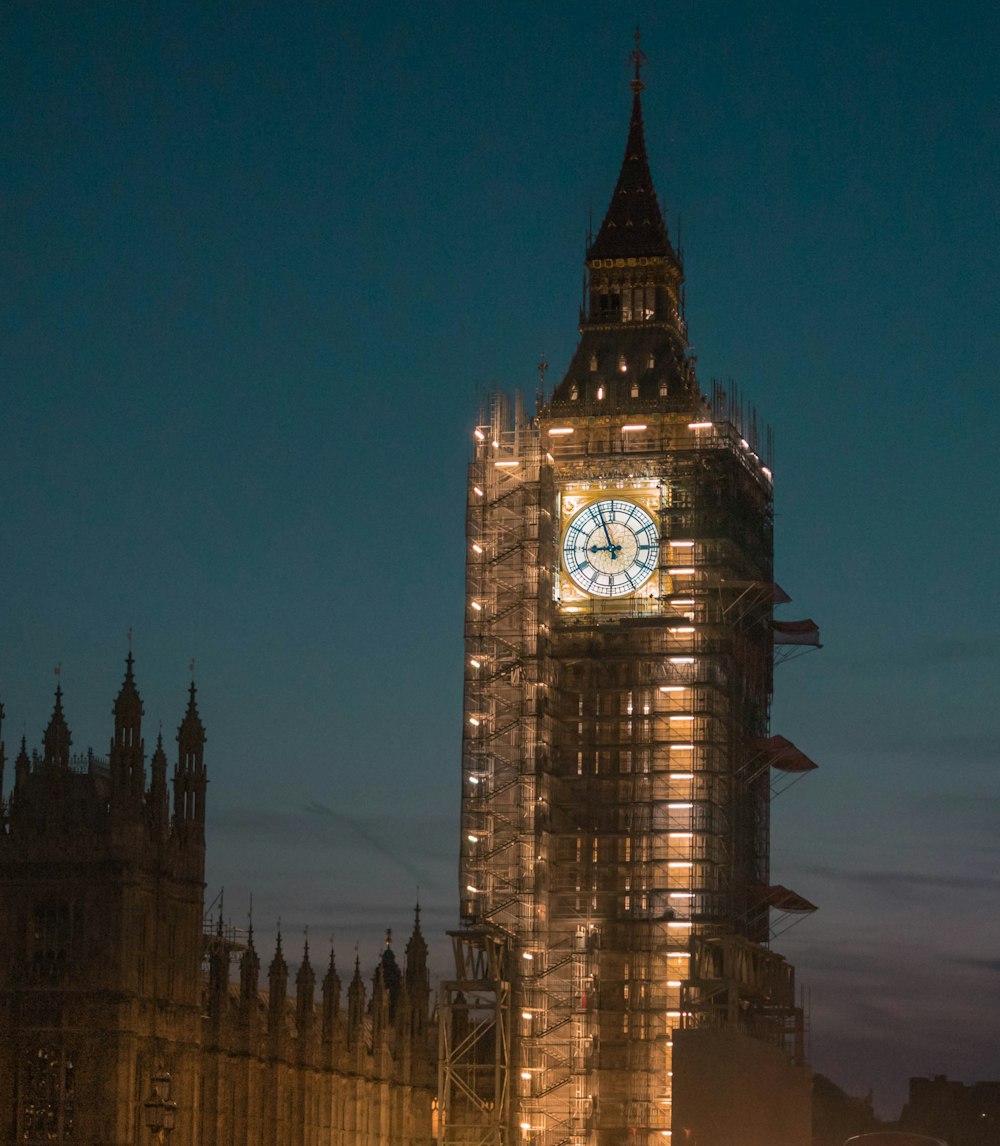 Una gran torre del reloj iluminada por la noche