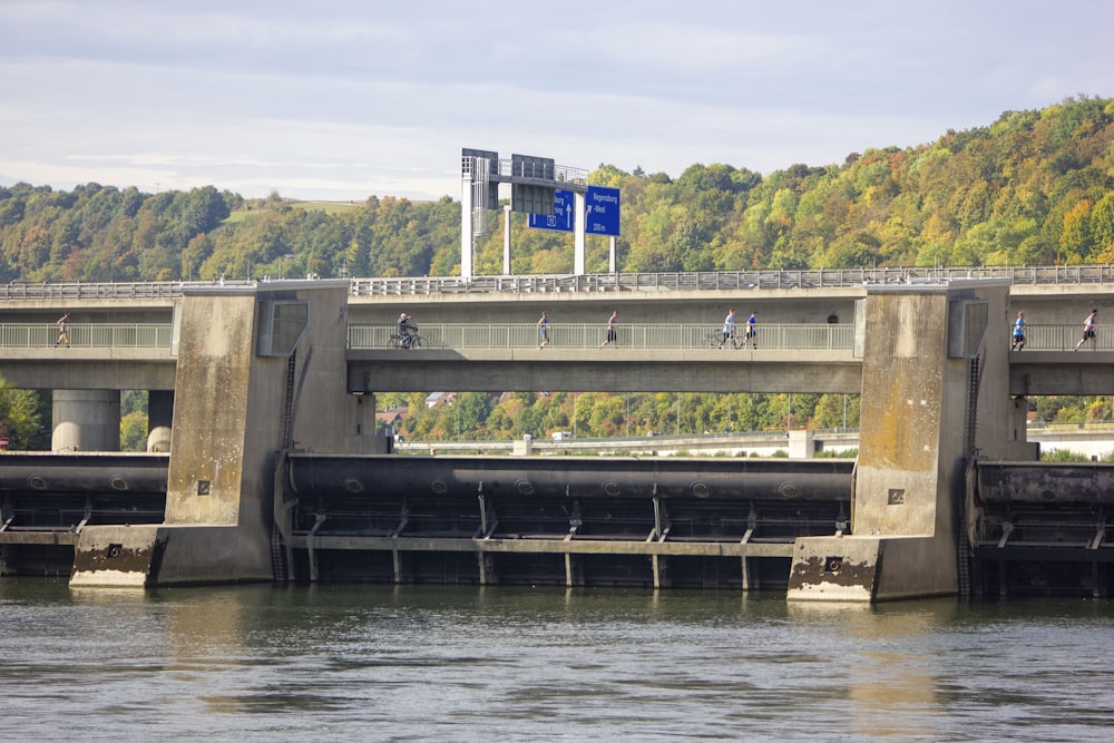 a bridge over a body of water with people riding bikes on it