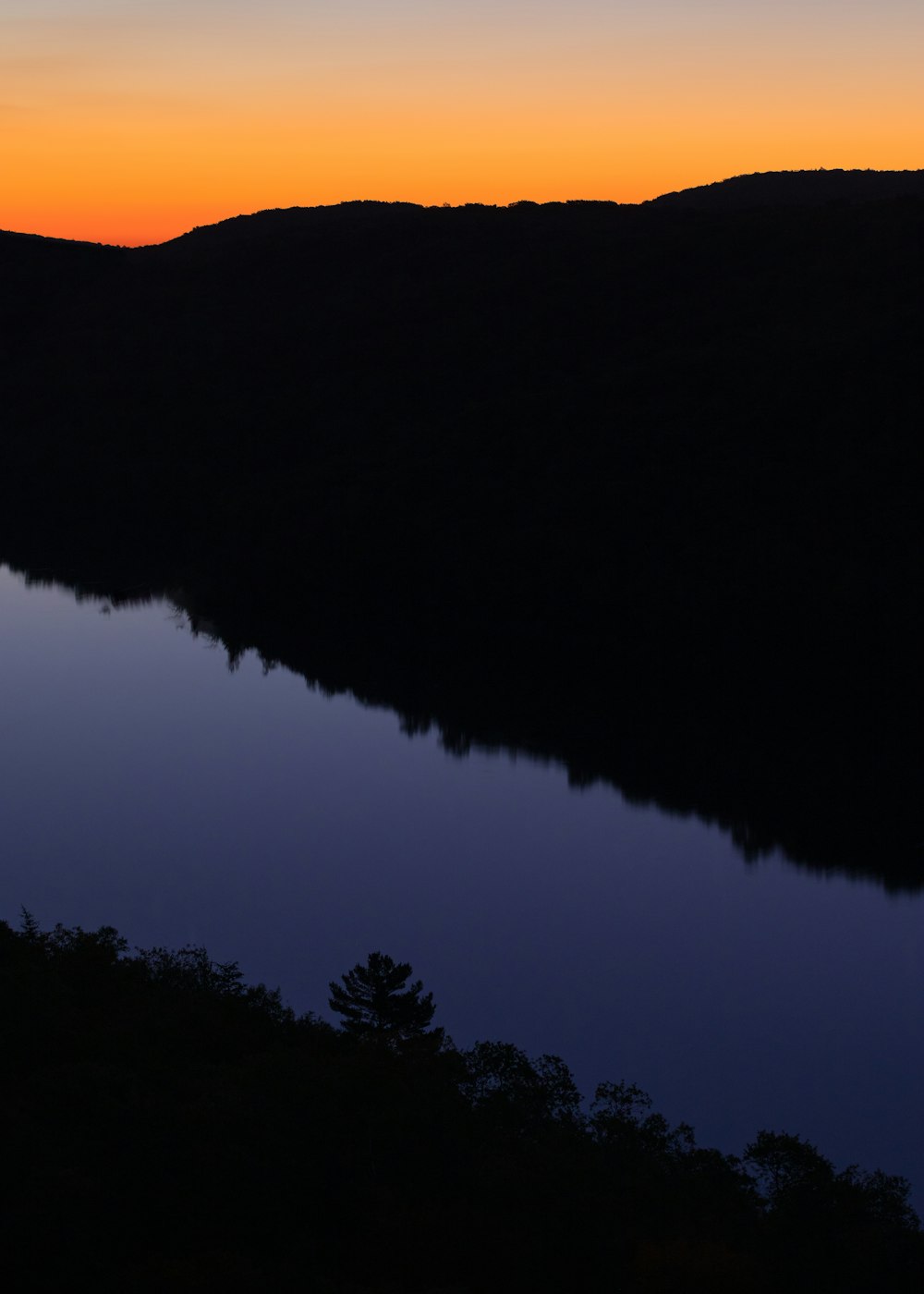 Il sole sta tramontando su un lago in montagna