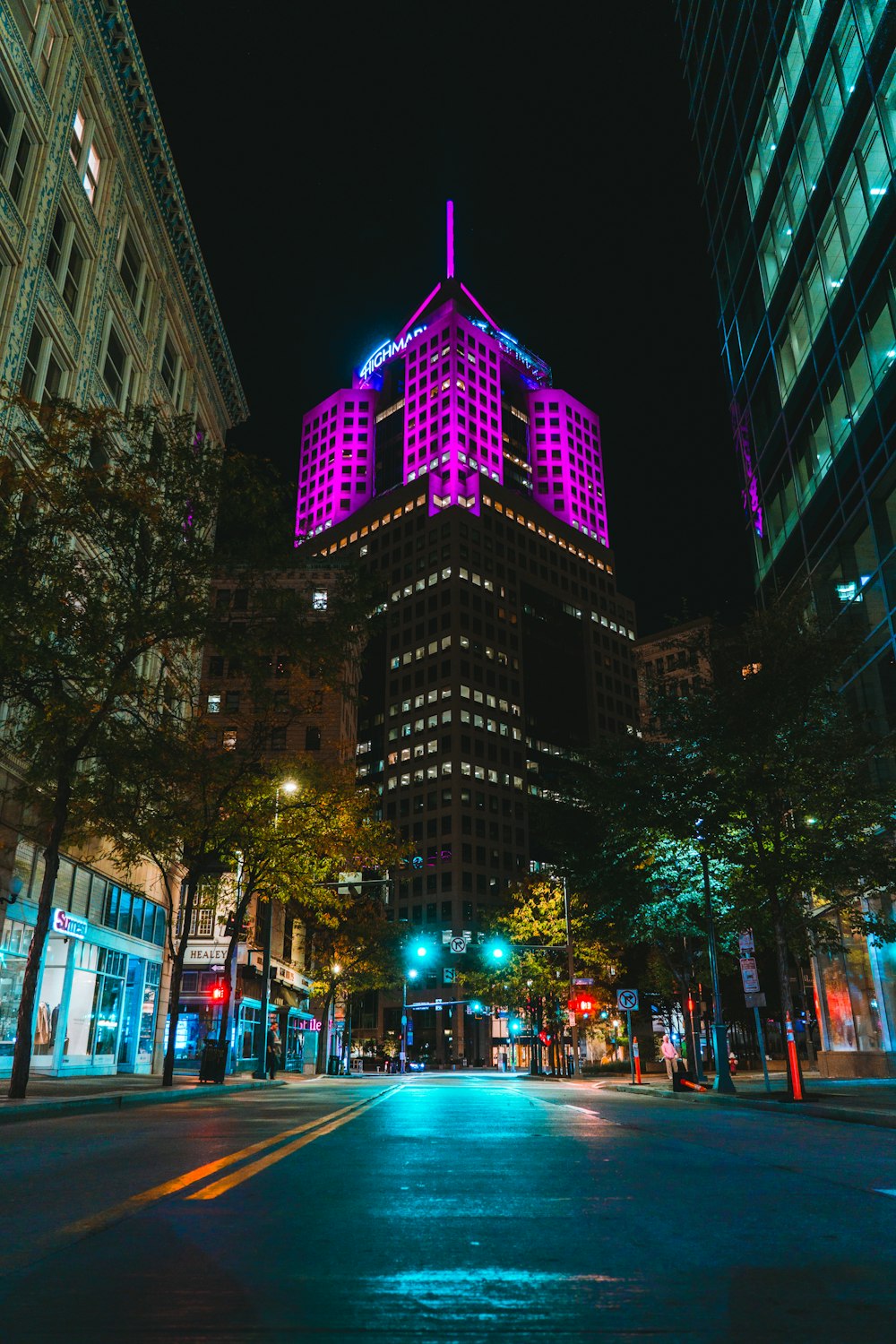 a city street with tall buildings lit up at night